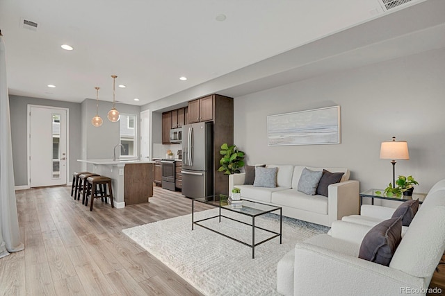 23615 E 5th Pl, Aurora, CO 80018 - living room with light wood-type flooring, recessed lighting, and baseboards