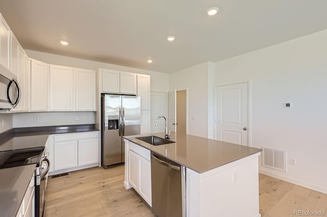 752 N Bently St, Watkins, CO 80137 - kitchen featuring stainless steel appliances, light wood-style floors, white cabinets, recessed lighting, and a center island with sink
