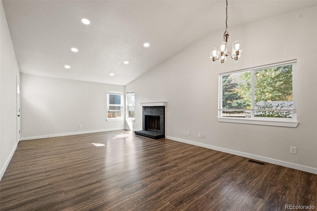 unfurnished living room with a wealth of natural light, dark wood-type flooring, a brick fireplace, and high vaulted ceiling