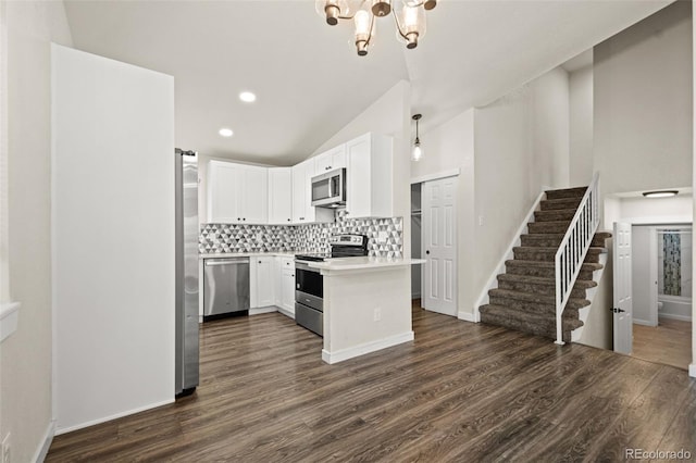 kitchen featuring white cabinetry, stainless steel appliances, vaulted ceiling, and dark hardwood / wood-style floors