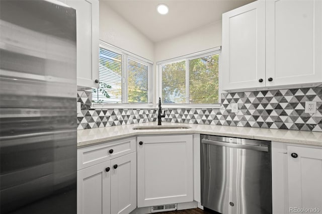 kitchen with appliances with stainless steel finishes, white cabinets, a healthy amount of sunlight, and sink