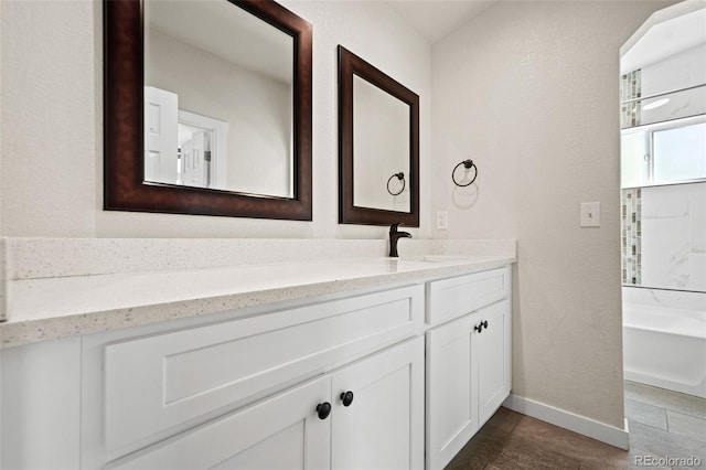 bathroom with vanity, tile patterned flooring, and a washtub