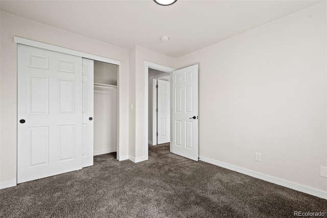 unfurnished bedroom featuring a closet and dark colored carpet