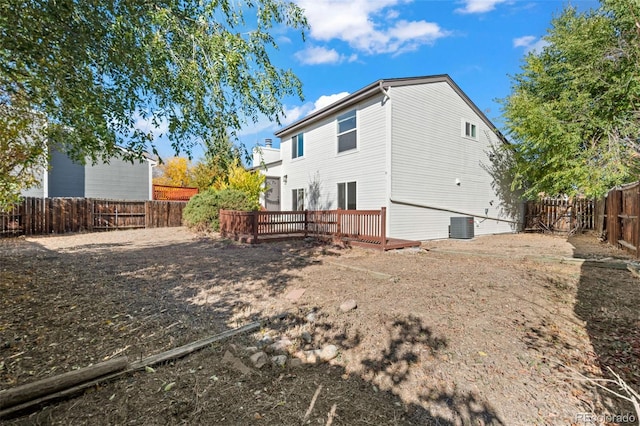 rear view of property with cooling unit and a deck