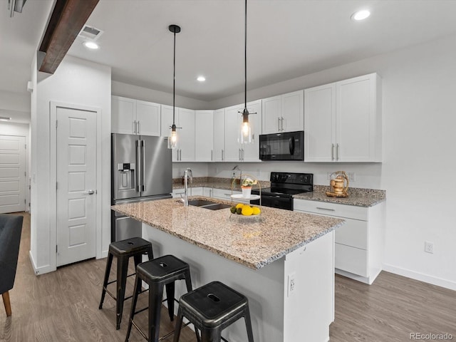 11719 W 45th Pl, Wheat Ridge, CO 80033 - kitchen featuring black appliances, a sink, baseboards, wood finished floors, and recessed lighting