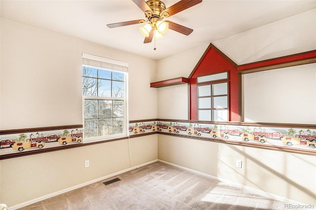 spare room featuring visible vents, baseboards, ceiling fan, and carpet floors