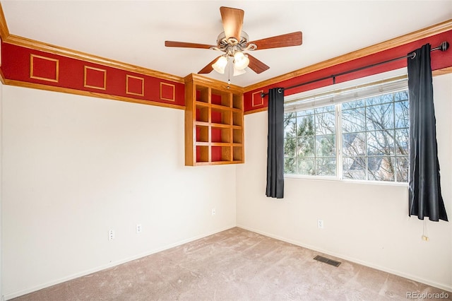 carpeted empty room featuring visible vents, baseboards, and a ceiling fan