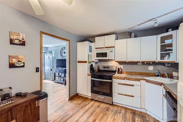 3512 E 117th Pl, Thornton, CO 80233 - kitchen featuring stainless steel range with gas cooktop, white microwave, black dishwasher, light wood finished floors, and a sink