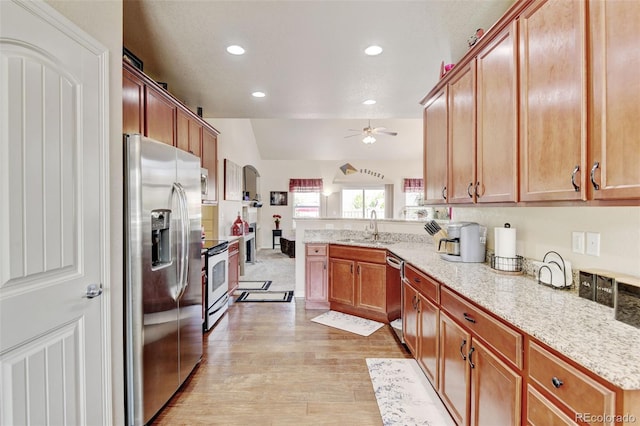 9046 Sandpiper Dr, Frederick, CO 80504 - kitchen with appliances with stainless steel finishes, a sink, ceiling fan, a peninsula, and light wood-style flooring