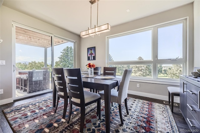 dining space with dark hardwood / wood-style flooring and a chandelier