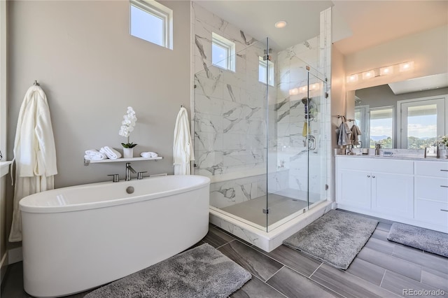 bathroom featuring vanity and shower with separate bathtub