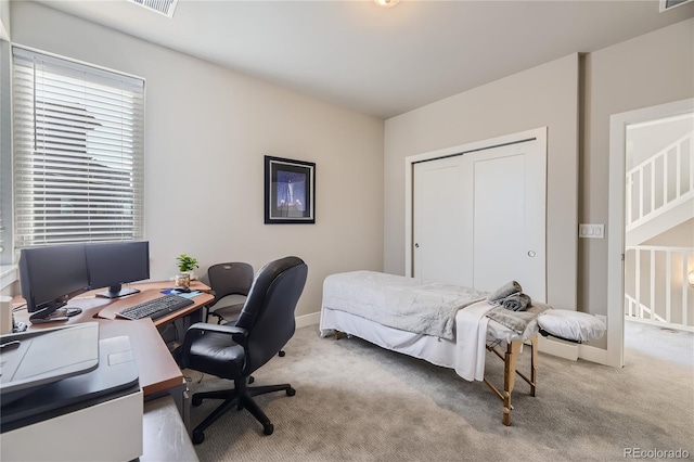 bedroom featuring light carpet and a closet