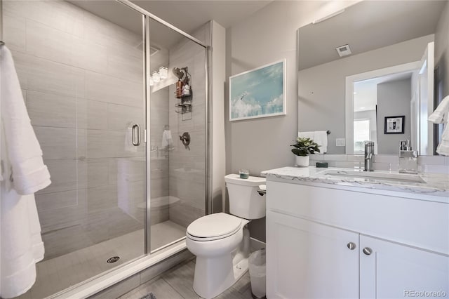 bathroom featuring vanity, toilet, and walk in shower