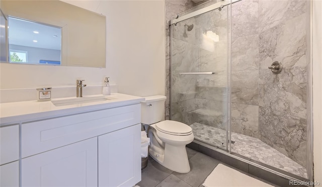 bathroom with vanity, toilet, and a shower with door