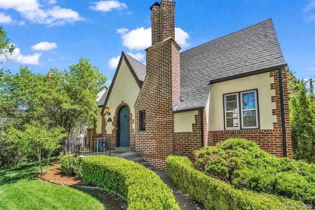 1300 Cherry St, Denver, CO 80220 - view of front of property featuring stucco siding, brick siding, a shingled roof, and a chimney