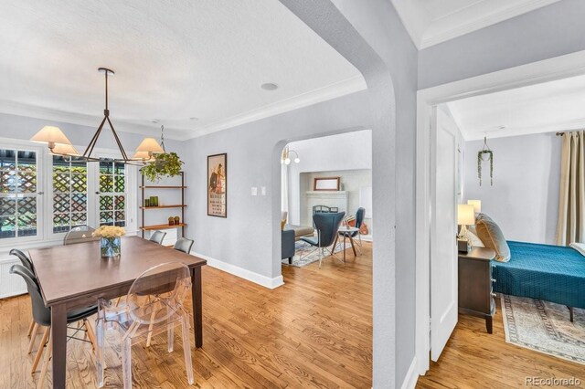 1300 Cherry St, Denver, CO 80220 - dining area with arched walkways, light wood-style flooring, ornamental molding, and baseboards