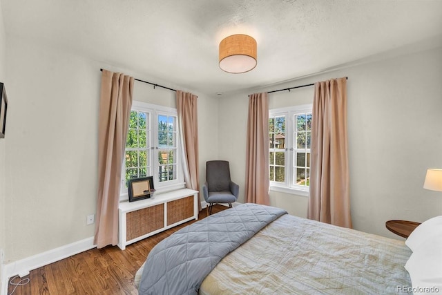 1300 Cherry St, Denver, CO 80220 - bedroom featuring radiator heating unit, multiple windows, wood finished floors, and baseboards