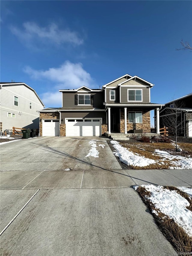 view of front of property with driveway, stone siding, and an attached garage