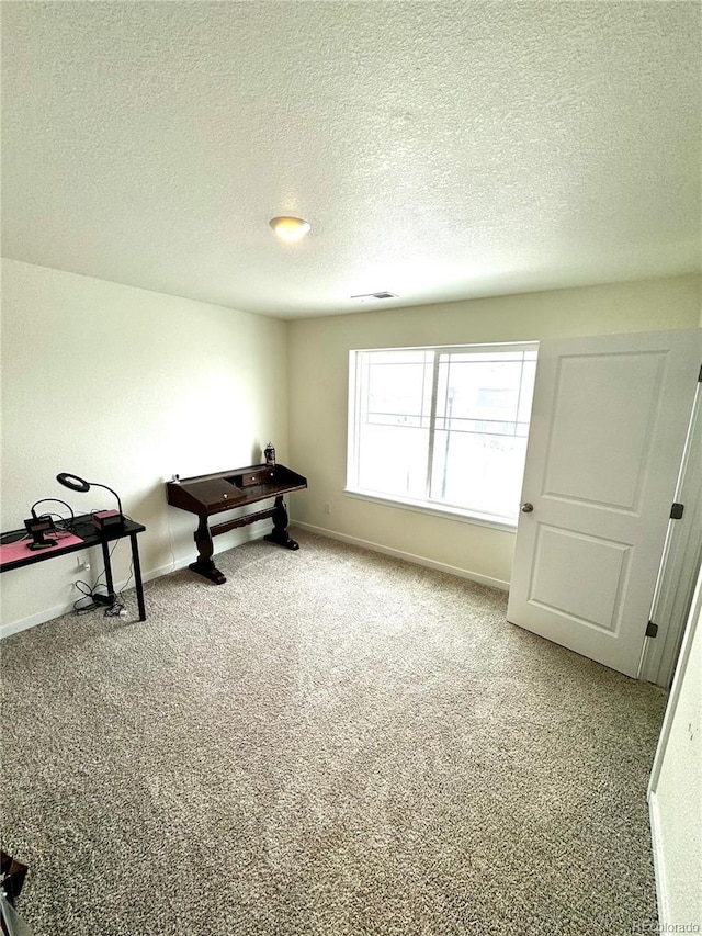 misc room with carpet floors, visible vents, a textured ceiling, and baseboards