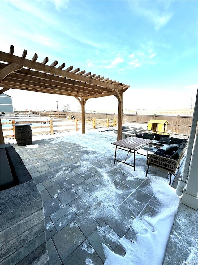 snow covered patio with fence and a pergola