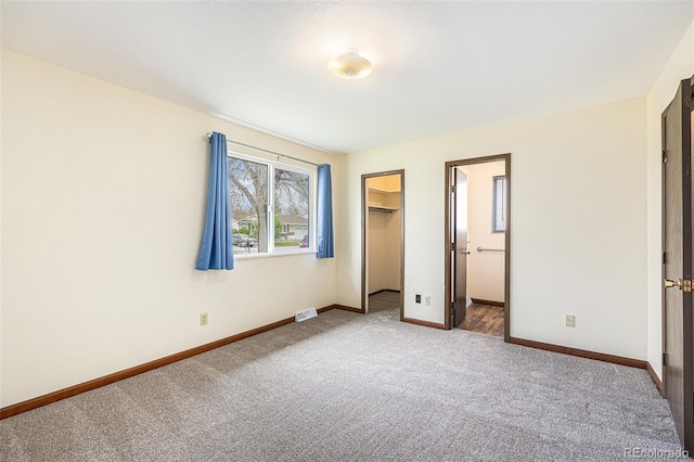 726 Mobile St, Aurora, CO 80011 - unfurnished bedroom featuring carpet floors, baseboards, a walk in closet, and a closet