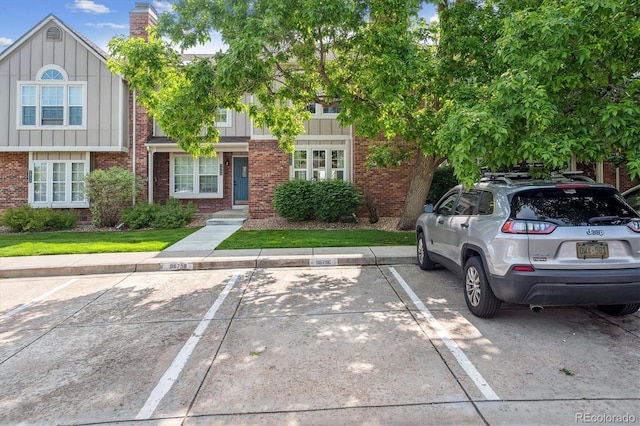 9679 W Chatfield Ave Unit C, Littleton, CO 80128 - townhome / multi-family property with board and batten siding, brick siding, uncovered parking, and a chimney