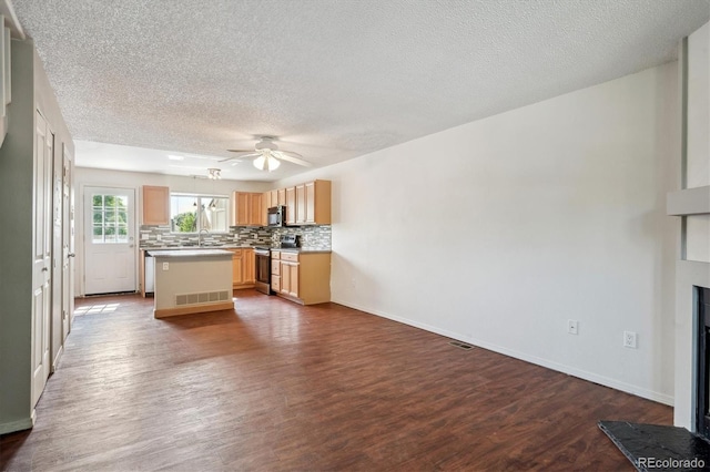 9679 W Chatfield Ave Unit C, Littleton, CO 80128 - kitchen featuring stainless steel appliances, a textured ceiling, dark wood-type flooring, light brown cabinetry, and decorative backsplash