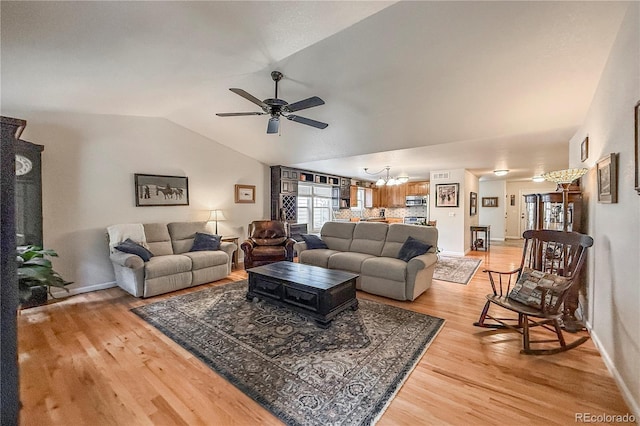 13642 Wrangler Way, Mead, CO 80542 - living area with a chandelier, ceiling fan, light wood-style floors, and vaulted ceiling