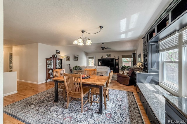 13642 Wrangler Way, Mead, CO 80542 - dining area featuring a chandelier, light wood-type flooring, a textured ceiling, and a ceiling fan