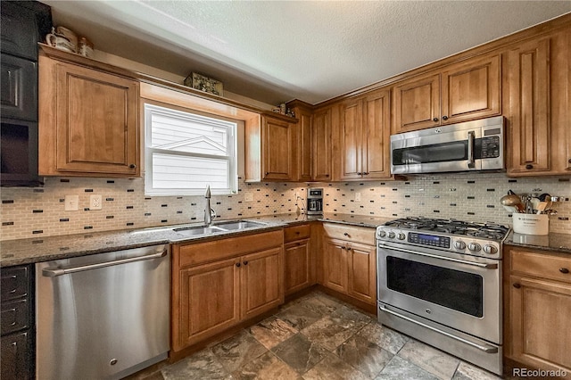 13642 Wrangler Way, Mead, CO 80542 - kitchen featuring stainless steel appliances, brown cabinets, dark stone counters, decorative backsplash, and a textured ceiling