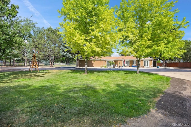 view of front of property with playground community and a front yard