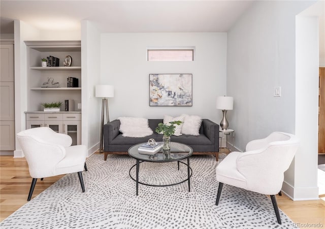 living area with baseboards and light wood finished floors