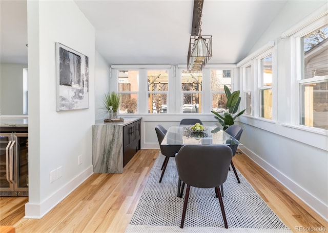 sunroom with wine cooler, a healthy amount of sunlight, and lofted ceiling