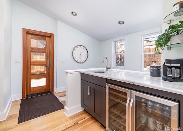 bar with beverage cooler, light wood-style flooring, a sink, and recessed lighting