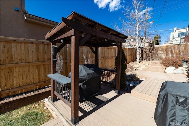 wooden deck with a fenced backyard and grilling area