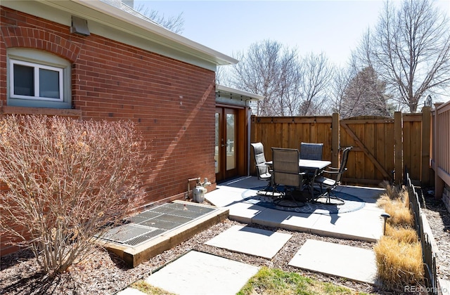 view of patio / terrace featuring a gate, fence, and outdoor dining space