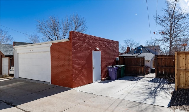 garage with fence and concrete driveway