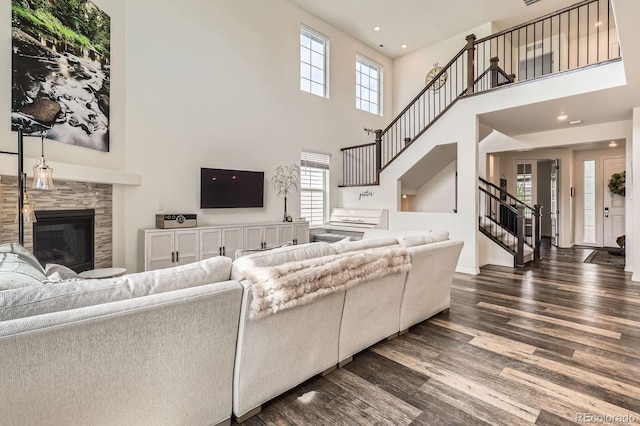 3162 Grizzly Peak Dr, Broomfield, CO 80023 - living area with stairway, dark wood-style floors, a high ceiling, a tiled fireplace, and baseboards