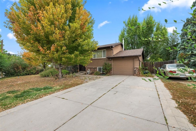 3010 Fireweed Dr, Colorado Springs, CO 80918 - view of front of house featuring stucco siding, driveway, stone siding, and a garage