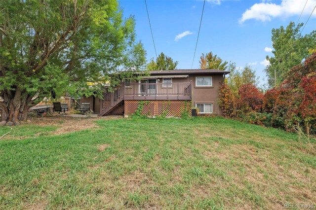 3010 Fireweed Dr, Colorado Springs, CO 80918 - rear view of property featuring a wooden deck, a lawn, stairway, and stucco siding