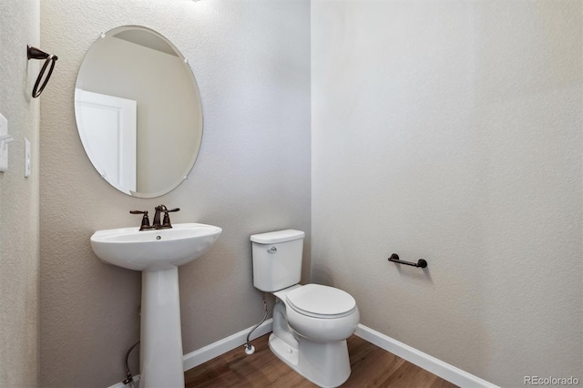 bathroom featuring hardwood / wood-style floors, toilet, and sink