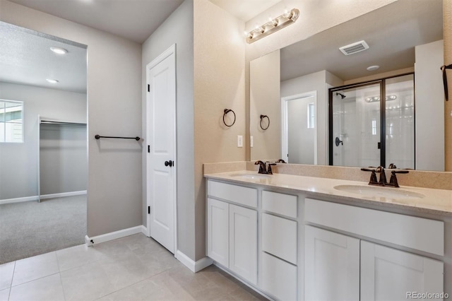 bathroom featuring tile patterned flooring, vanity, and walk in shower