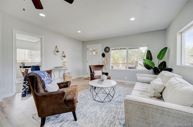 living room with ceiling fan and light hardwood / wood-style flooring