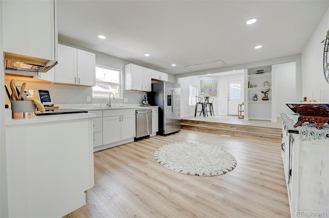 kitchen featuring white cabinets, appliances with stainless steel finishes, light wood-type flooring, and sink