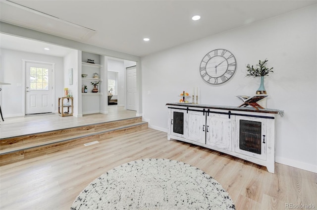 bar featuring built in features and light hardwood / wood-style floors