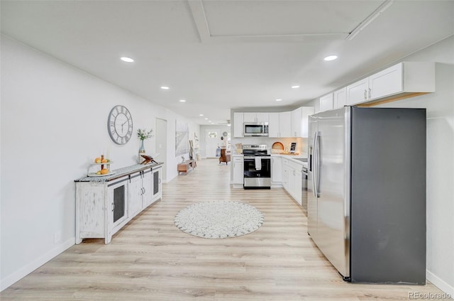 kitchen featuring white cabinets, appliances with stainless steel finishes, and light hardwood / wood-style floors