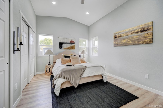 bedroom featuring a closet, light wood-type flooring, and vaulted ceiling