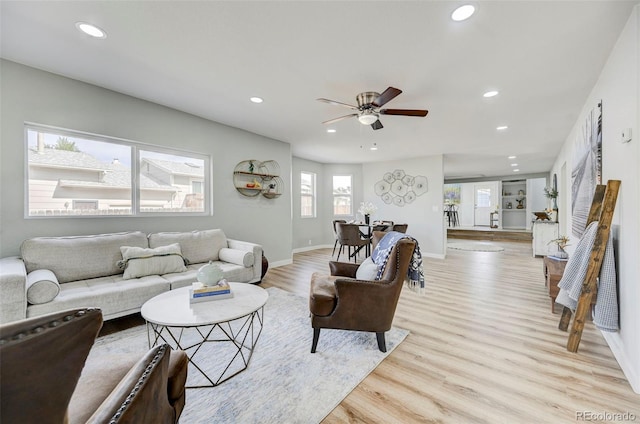 living room featuring ceiling fan, plenty of natural light, and light hardwood / wood-style floors