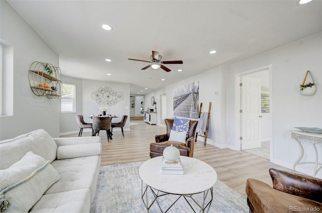 living room featuring light hardwood / wood-style flooring and ceiling fan