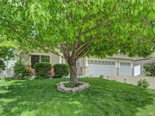 obstructed view of property with stucco siding, stone siding, driveway, and a front lawn